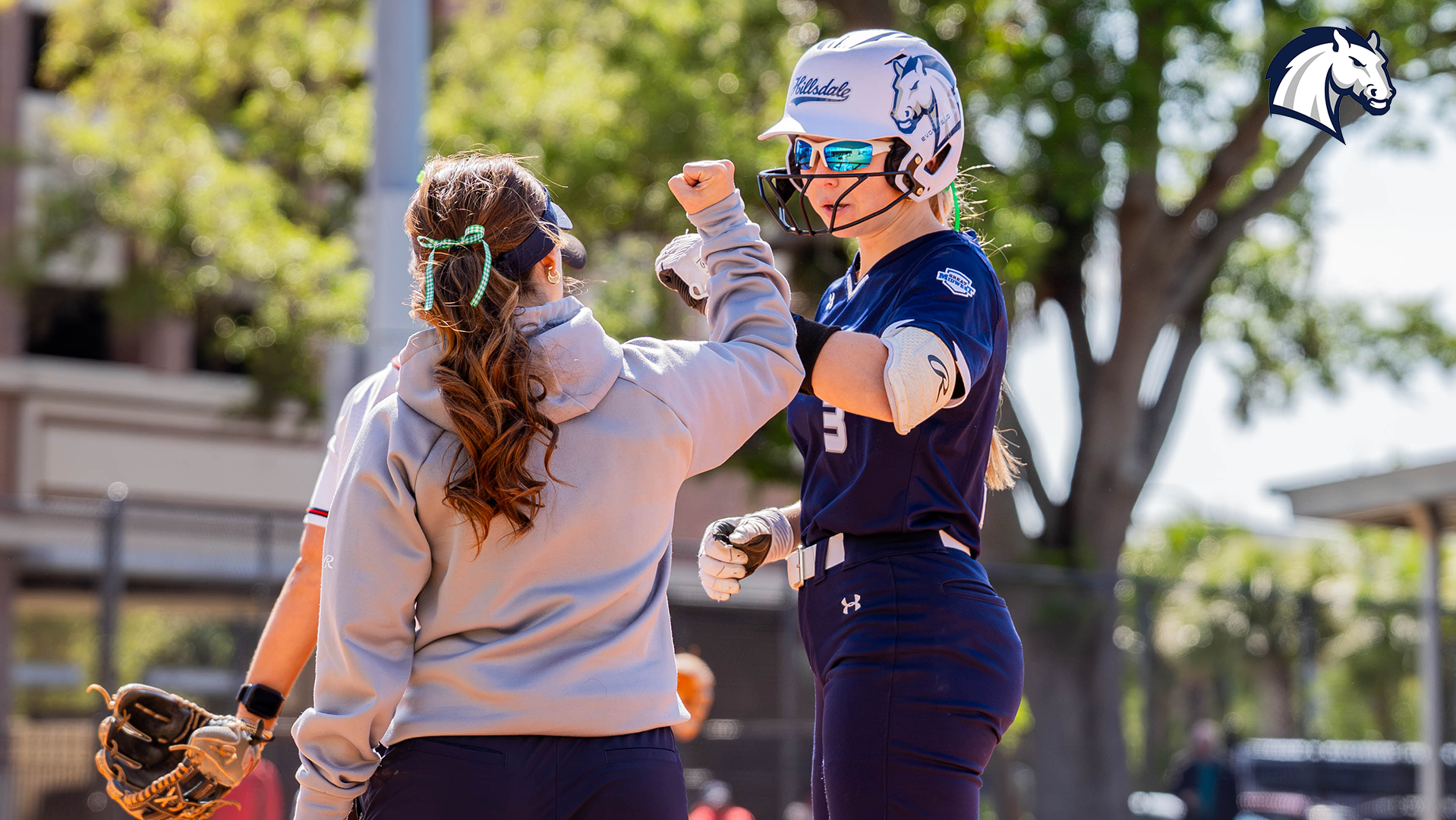 Hillsdale's Nathalie Hagle (right) gets congratulations from assistant coach Taylor Segorski after a base hit against Tampa on March 17, 2026.