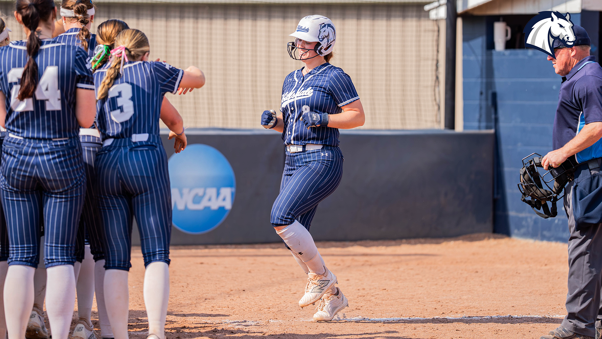 Hillsdale's Anna Chellman (right) heads for home plate to meet her teammates after a home run against Cedarville on March 30, 2026.