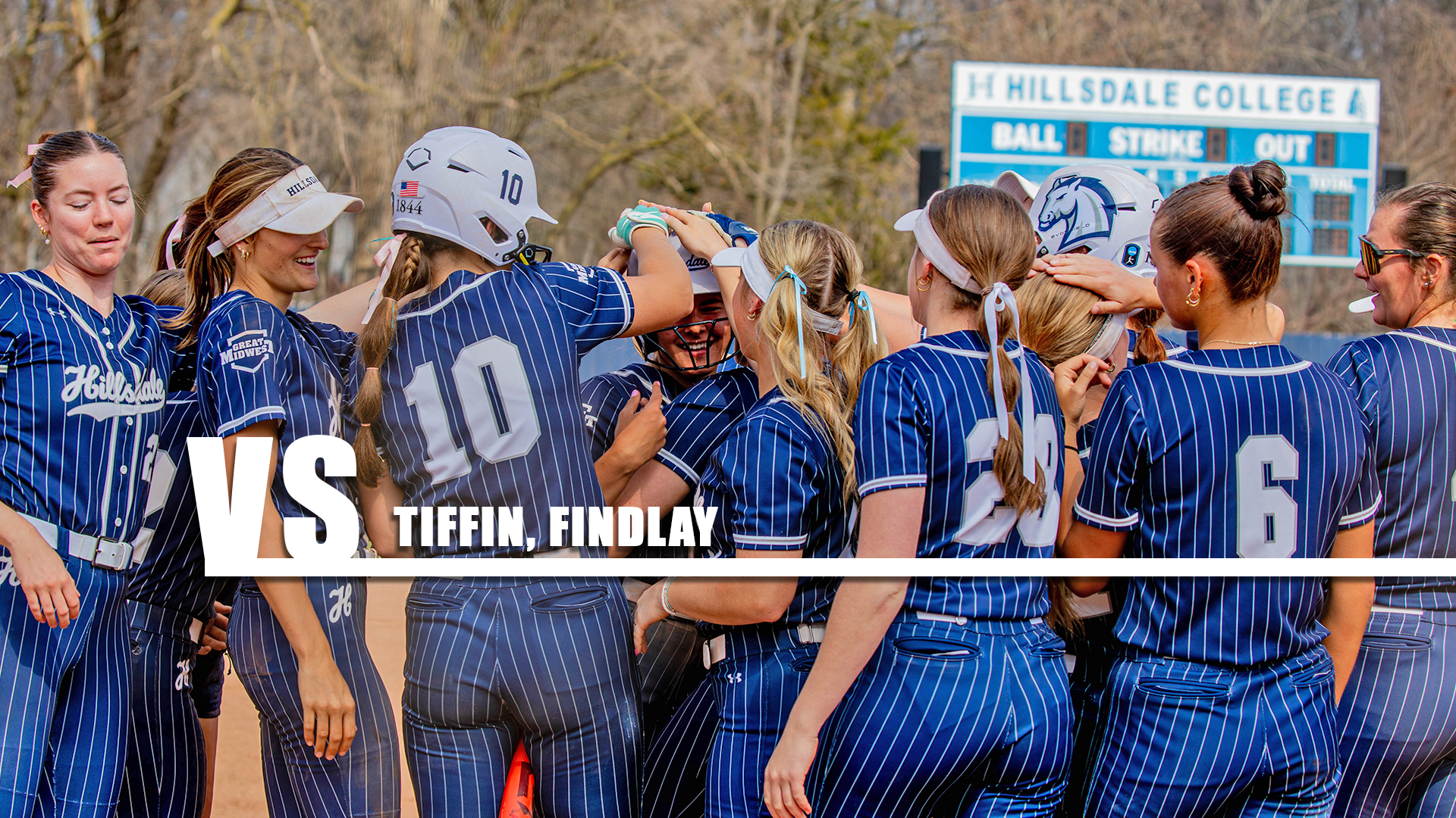 Hillsdale players celebrate at home plate after a home run against Cedarville on March 30, 2026.