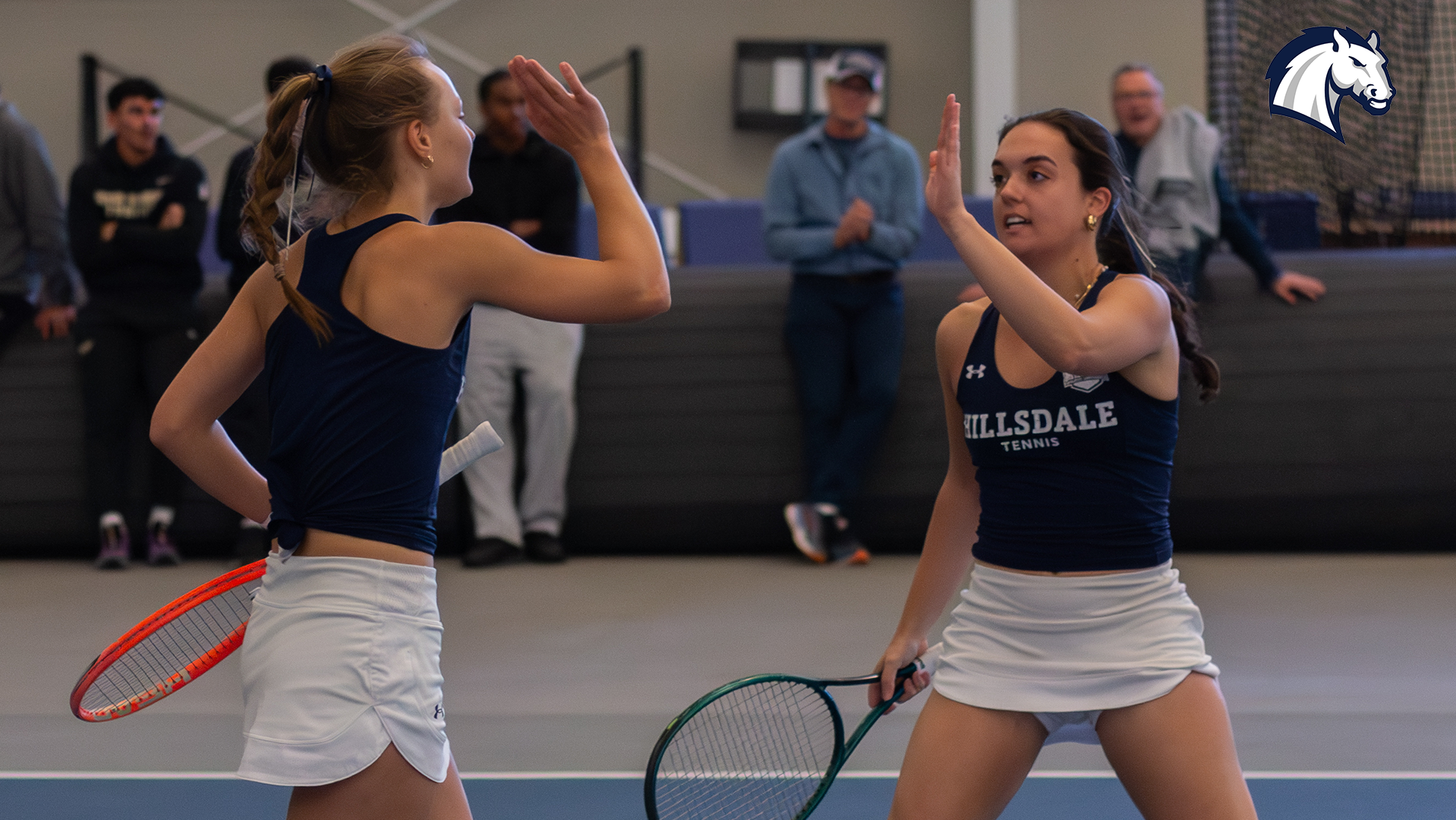 Hillsdale's Esther Sura (left) and Dimitra Papastavrou congratulate each other after winning a point in doubles against Tiffin on March 28, 2026.