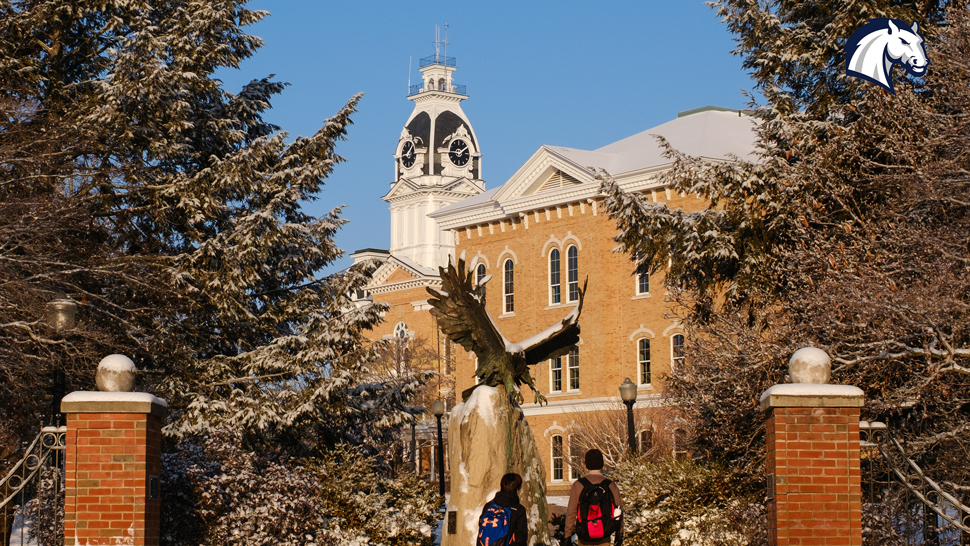 Photo of the entrance to the Hillsdale College campus, displaying both the eagle statue and the clock tower of Central Hall.