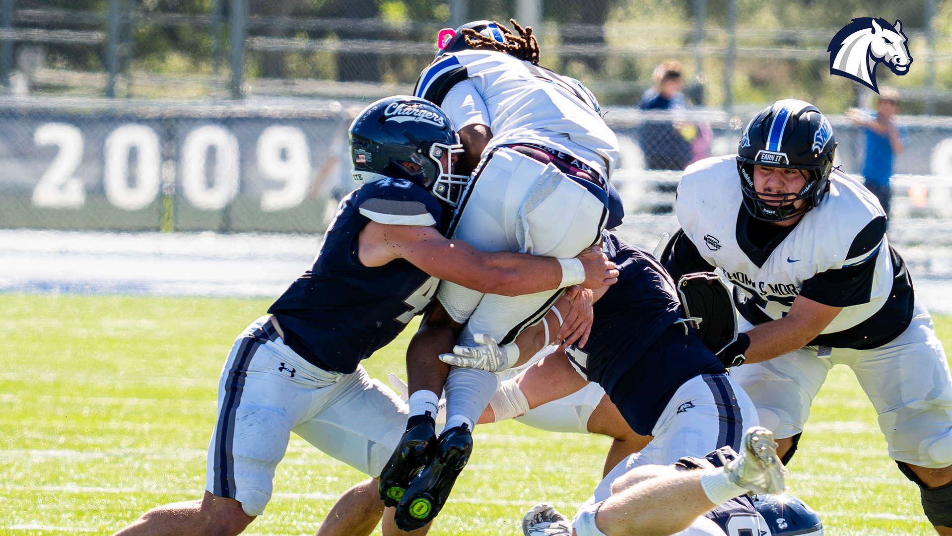 Hillsdale's Luke Penola (43) and Alex Lee (31) tackle a Thomas More receiver during a 38-7 win on Sept. 26, 2026.