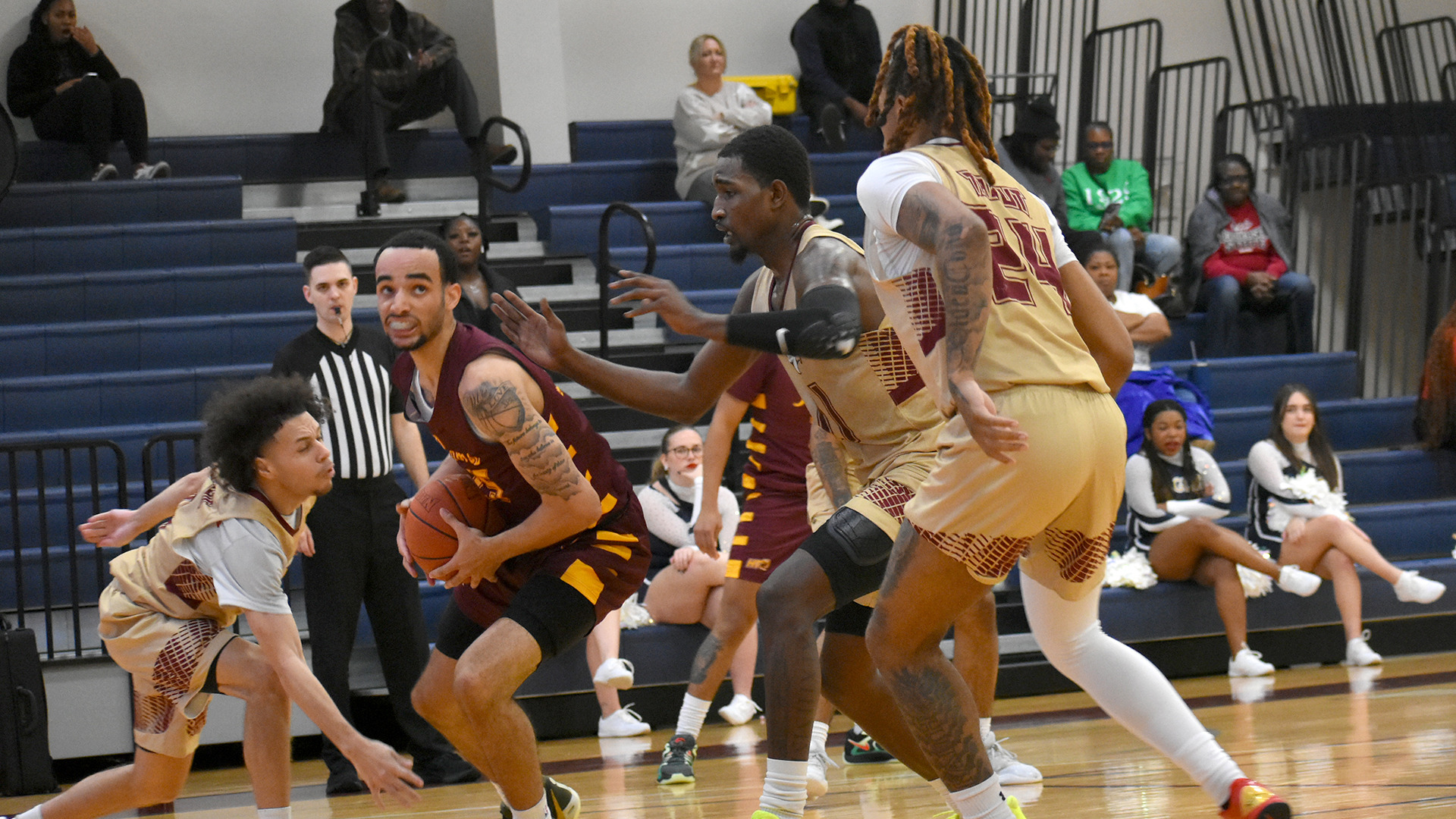 Cade Holzman (with ball) makes a move to the basket against two Texas A&M–Texarkana defenders