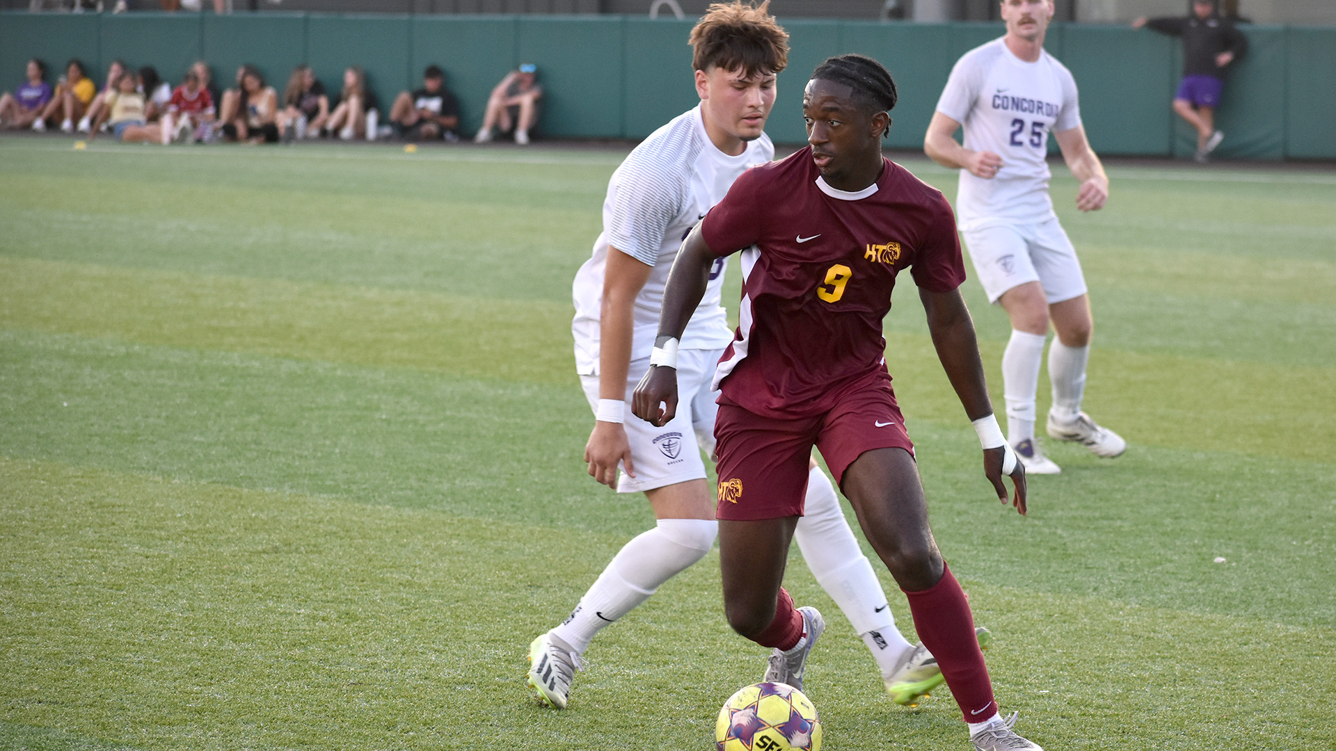 Men's soccer player Christian Kisukulu looks for a teammate to pass to while being closely defended in HT's match against Concordia earlier this season