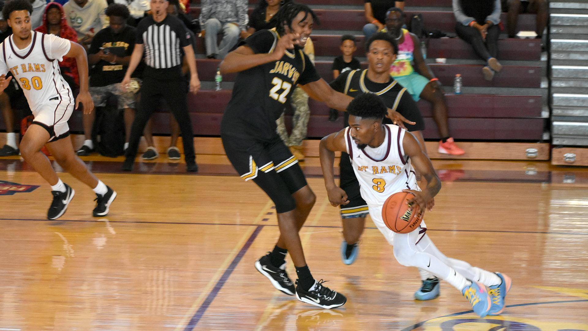 Caleb Campbell dribbles past two Jarvis Christian defenders in an HT home game at Branch Gymnasium (Oct. 25, 2025)