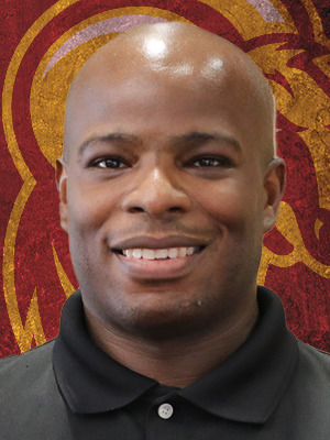 Staff photo head shot of John Smith, HT men's basketball coach (against a backdrop of the HT Ram logo)