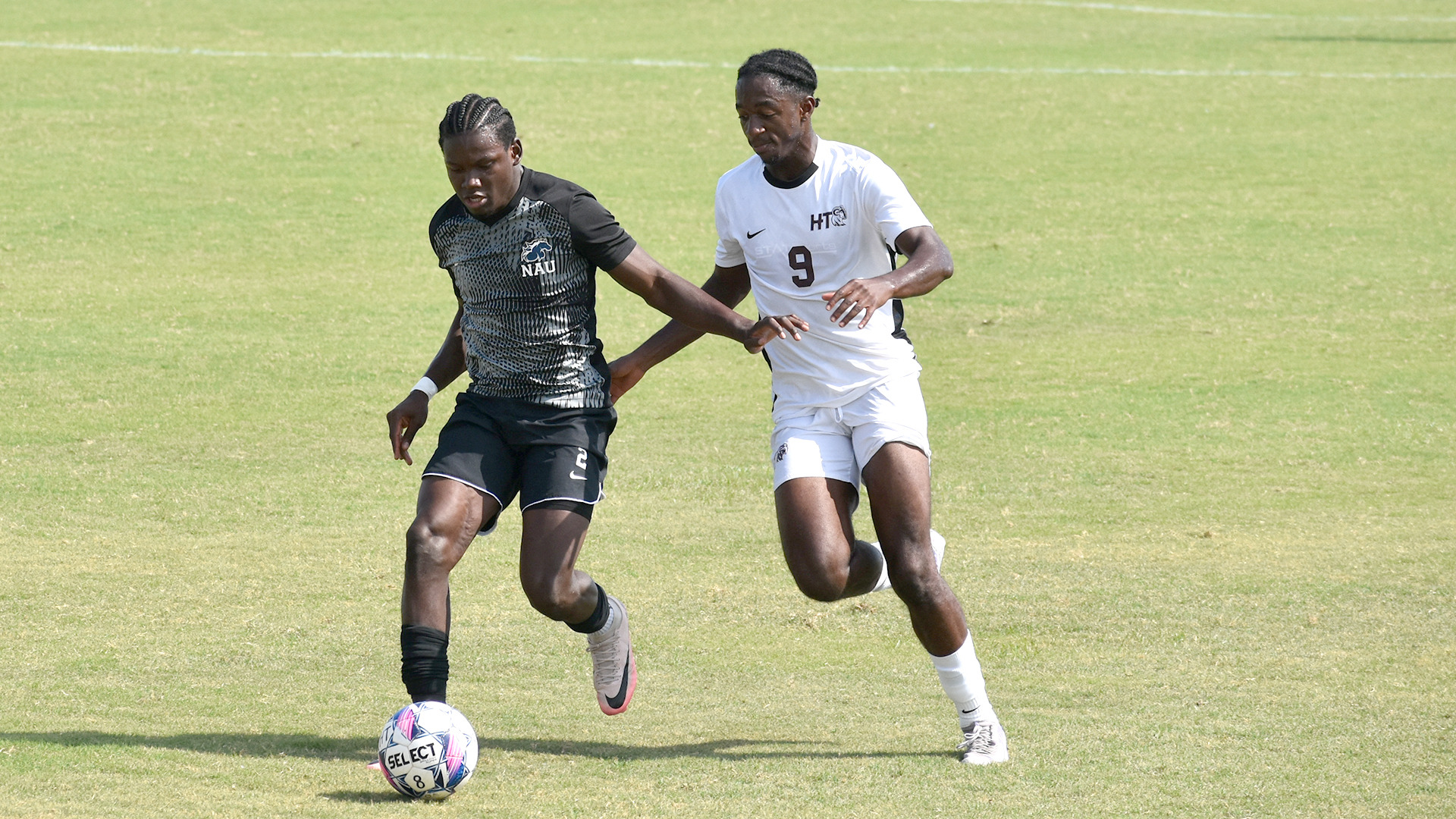 HT men's soccer Christian Kisukulu challenges a North American (Texas) University player for the ball