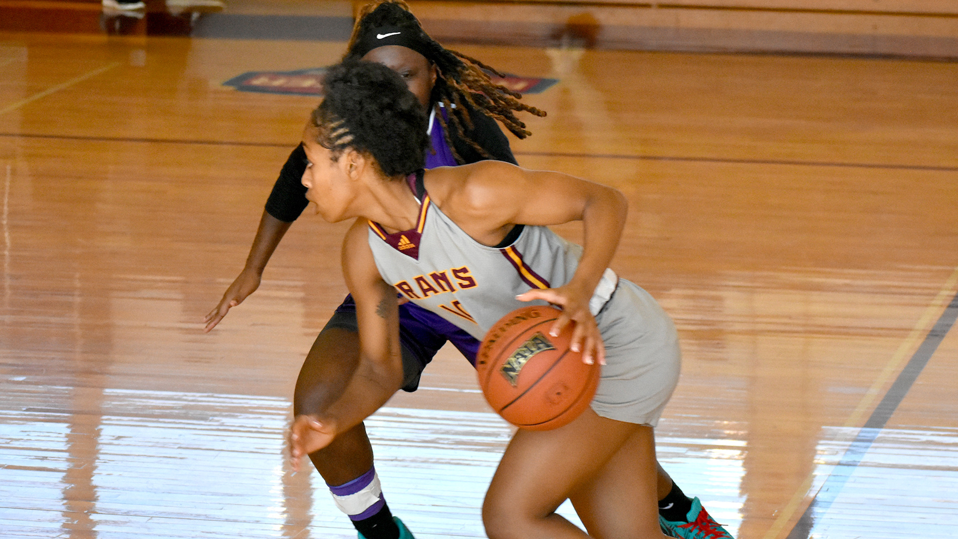 HT women's basketball player Destiny Stanford dribbles past a Wiley defender