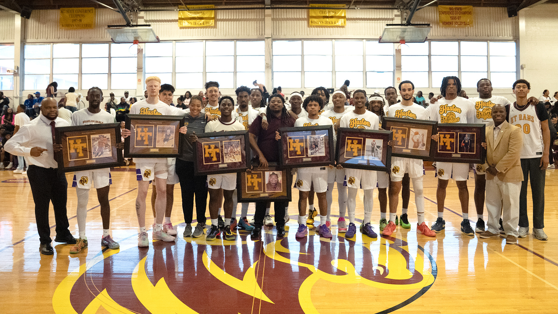 HT's Men's Basketball Seniors pose with their teammates and coaches while displaying their senior gifts