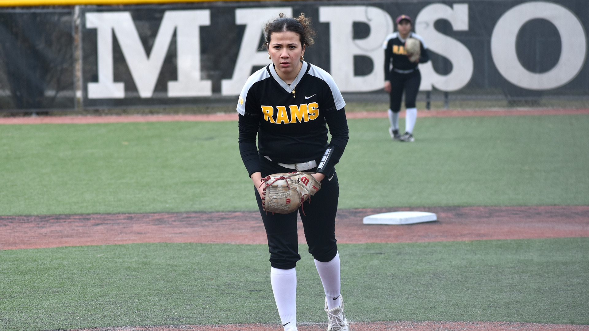HT softball player Alexis Tamez prepares to wind up for a pitch in a game against McMurry. HT's centerfielder is visible in the far background.