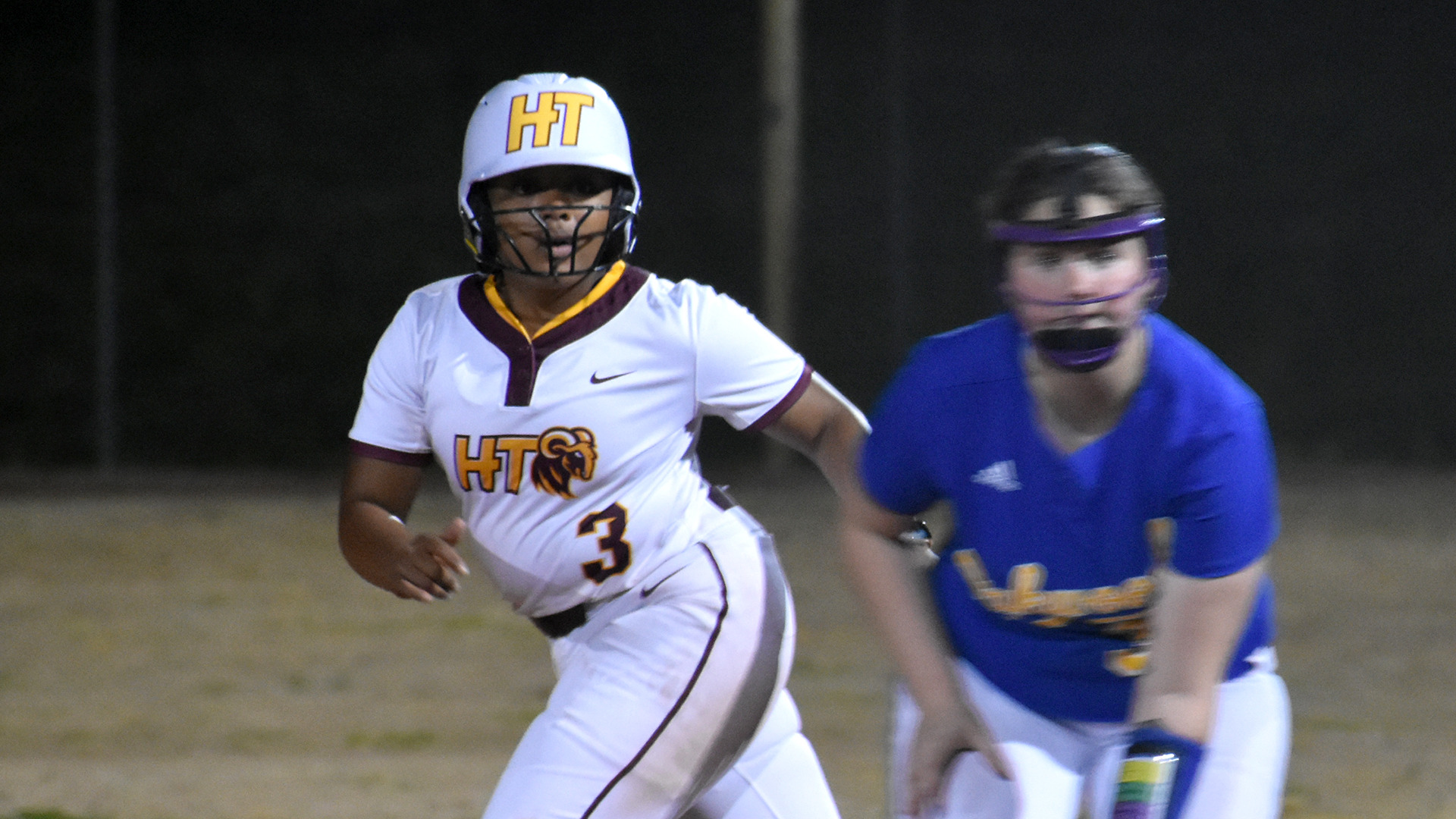 Madison Stimpson (3) prepares to run from first to second base in a Saturday night game at Oakwood (Ala.). Oakwood's first base-person is also visible (though blurred in the photo).