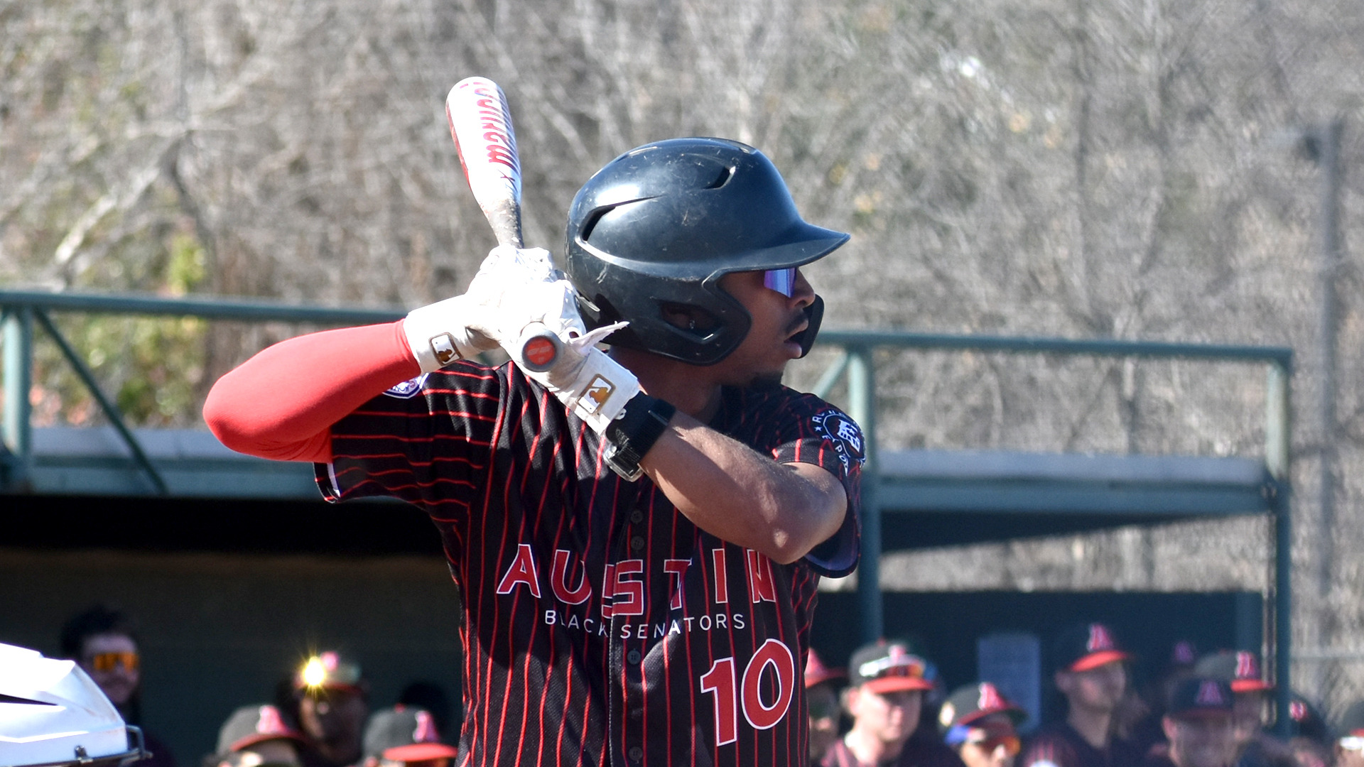 A closeup of Jayden Corzine batting right-handed against Mission (Mo.) while wearing HT's Austin Black Senators throwback jerseys