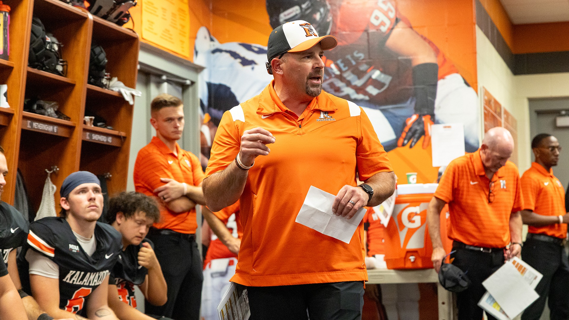 Kalamazoo College Head Football Coach Jamie Zorbo speaking to the team in the locker room.