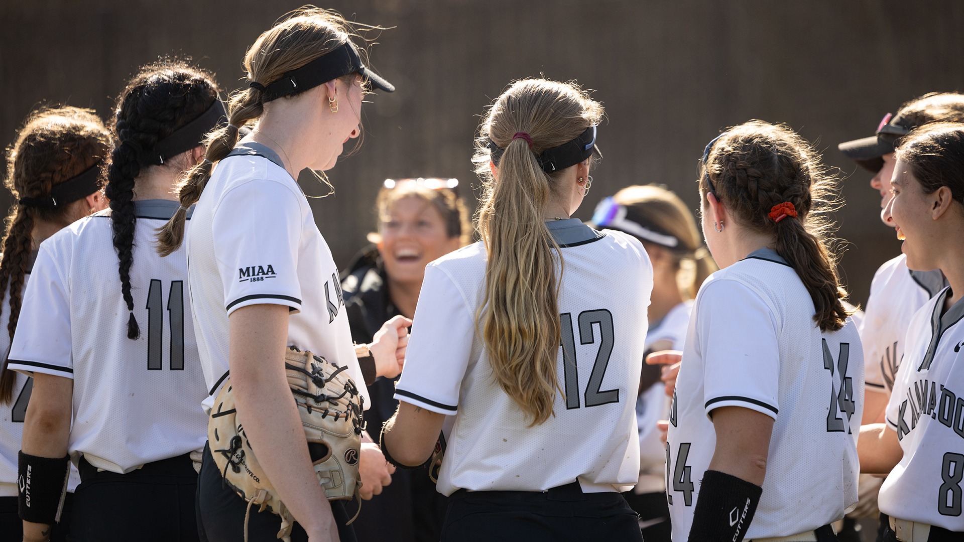 Kalamazoo College softball team in a huddle