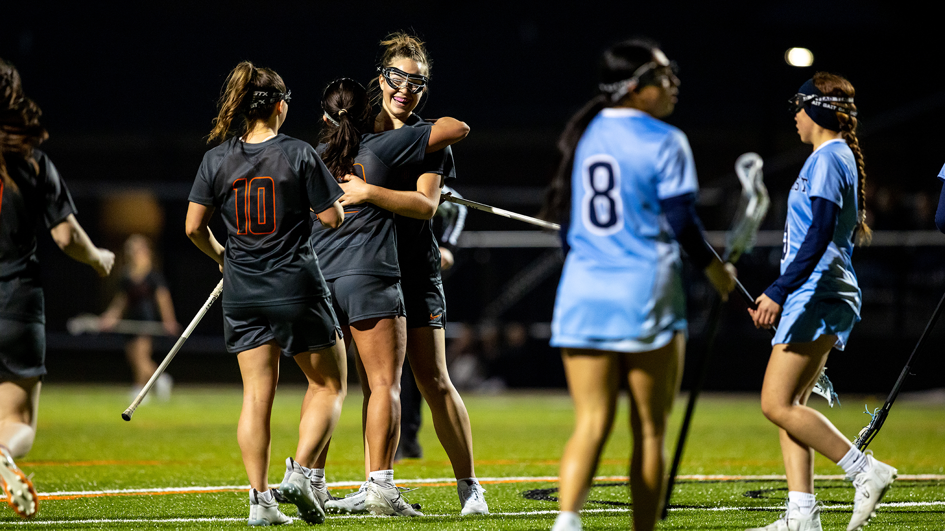 Kalamazoo College women's lacrosse players celebrate a goal
