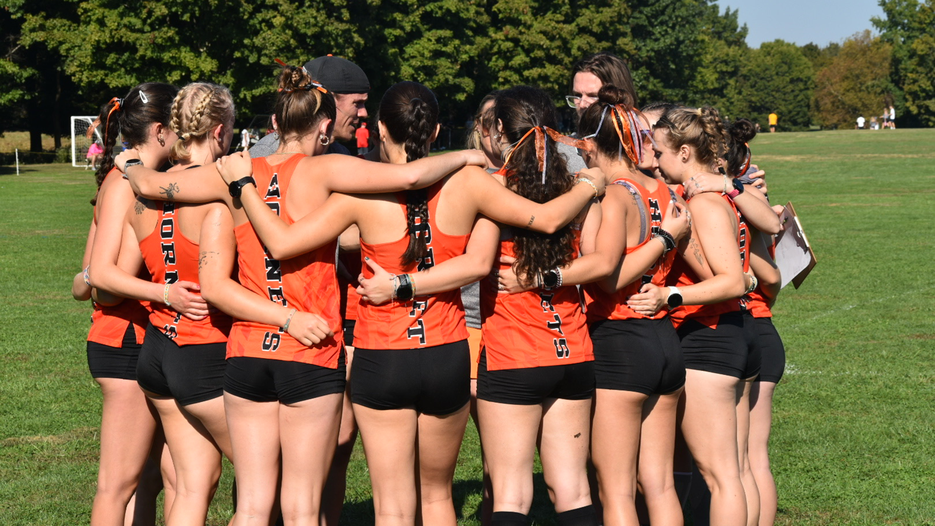 The Kalamazoo College women's cross country team in a huddle