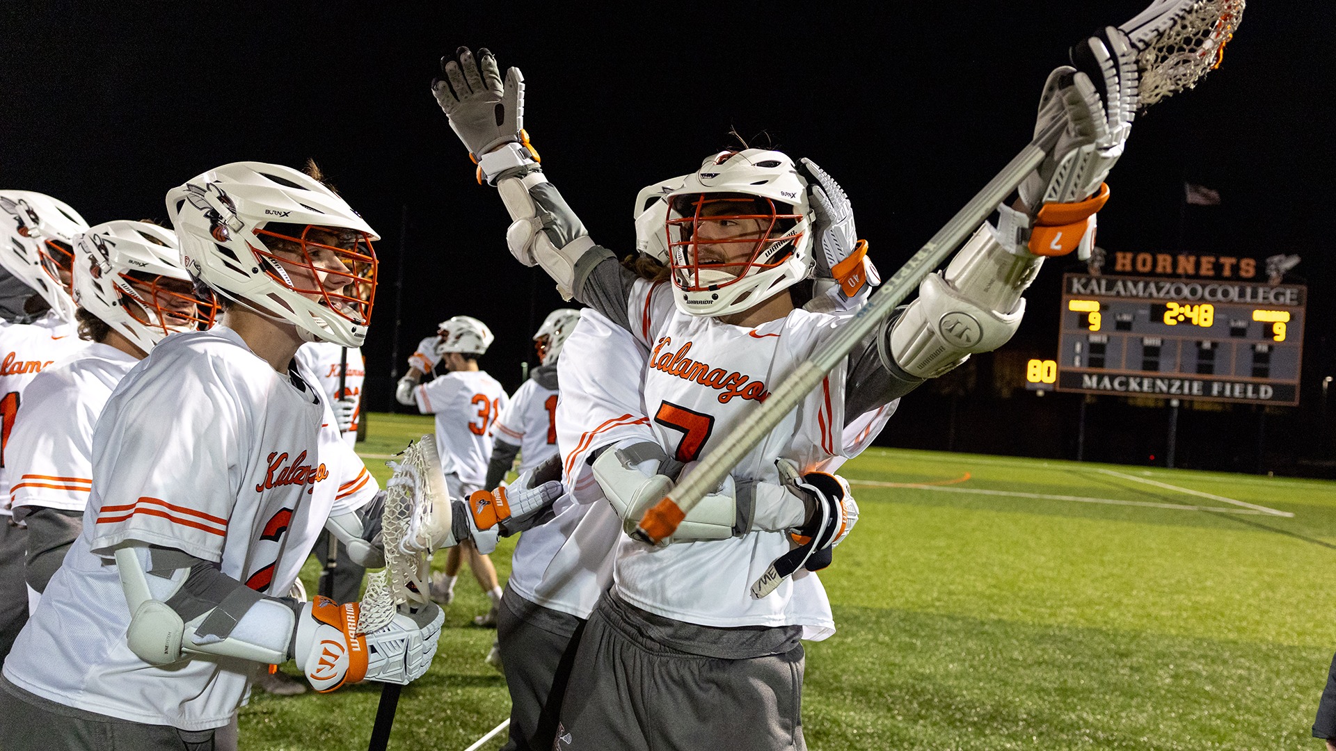 Dylan Adkins and Kalamazoo College men's lacrosse players celebrating a win