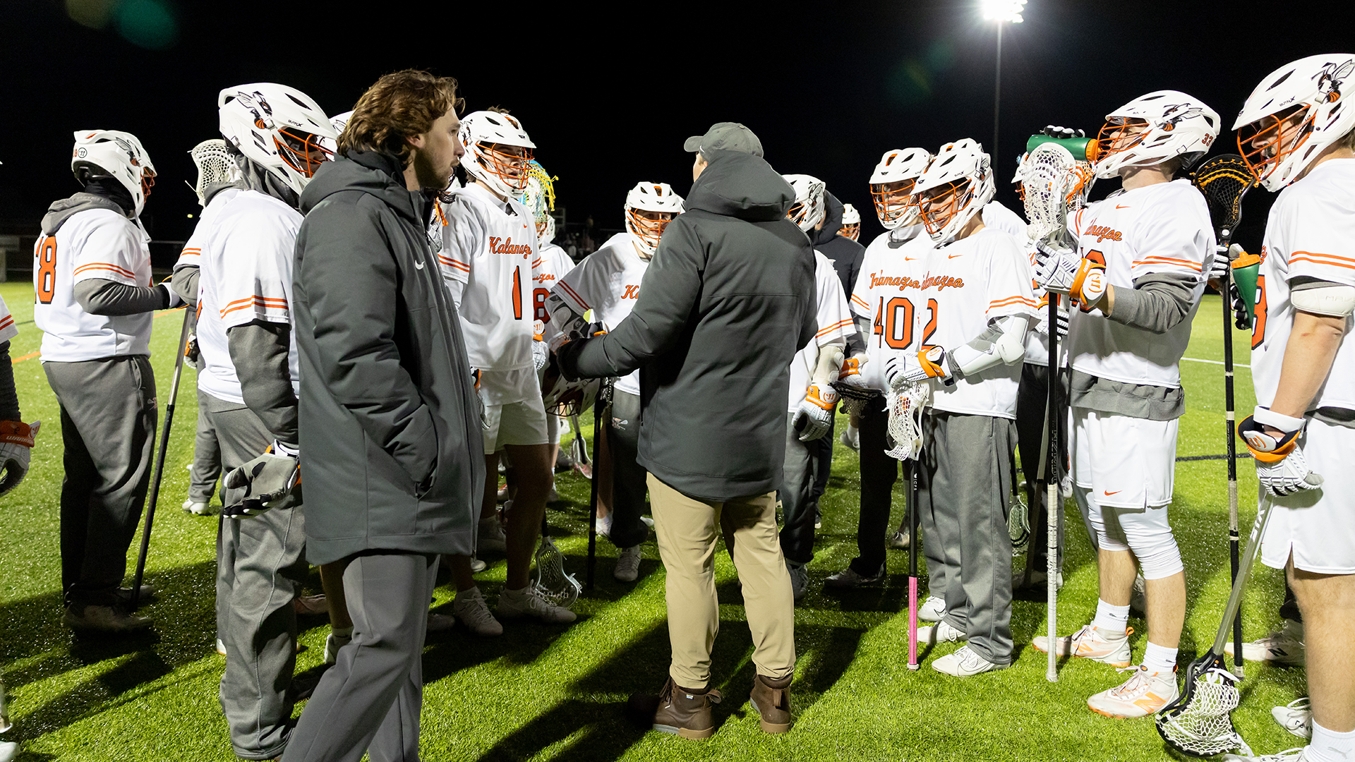The Kalamazoo College men's lacrosse team huddled around head coach Vince Redko