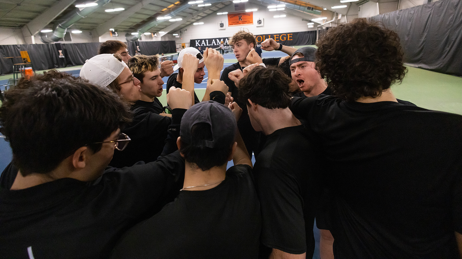 The Kalamazoo College men's tennis team huddled in Markin Tennis Center