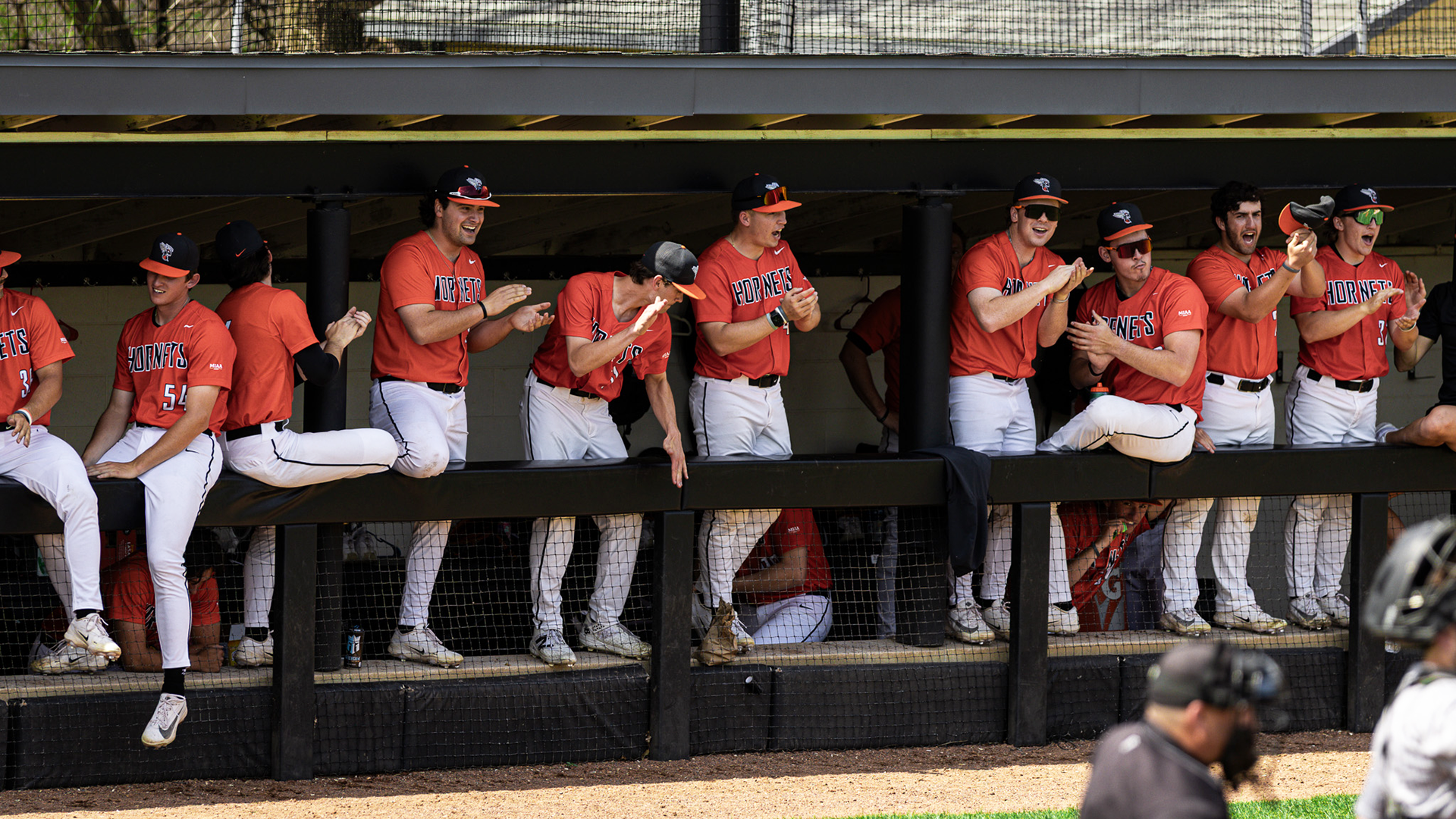The Kalamazoo College baseball team celebrating in the dugout