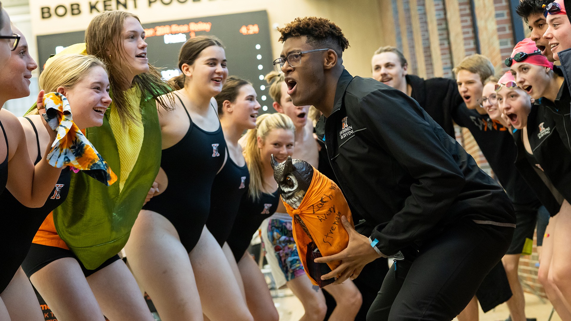 Kalamazoo College Swimming and Diving teams celebrating in a huddle
