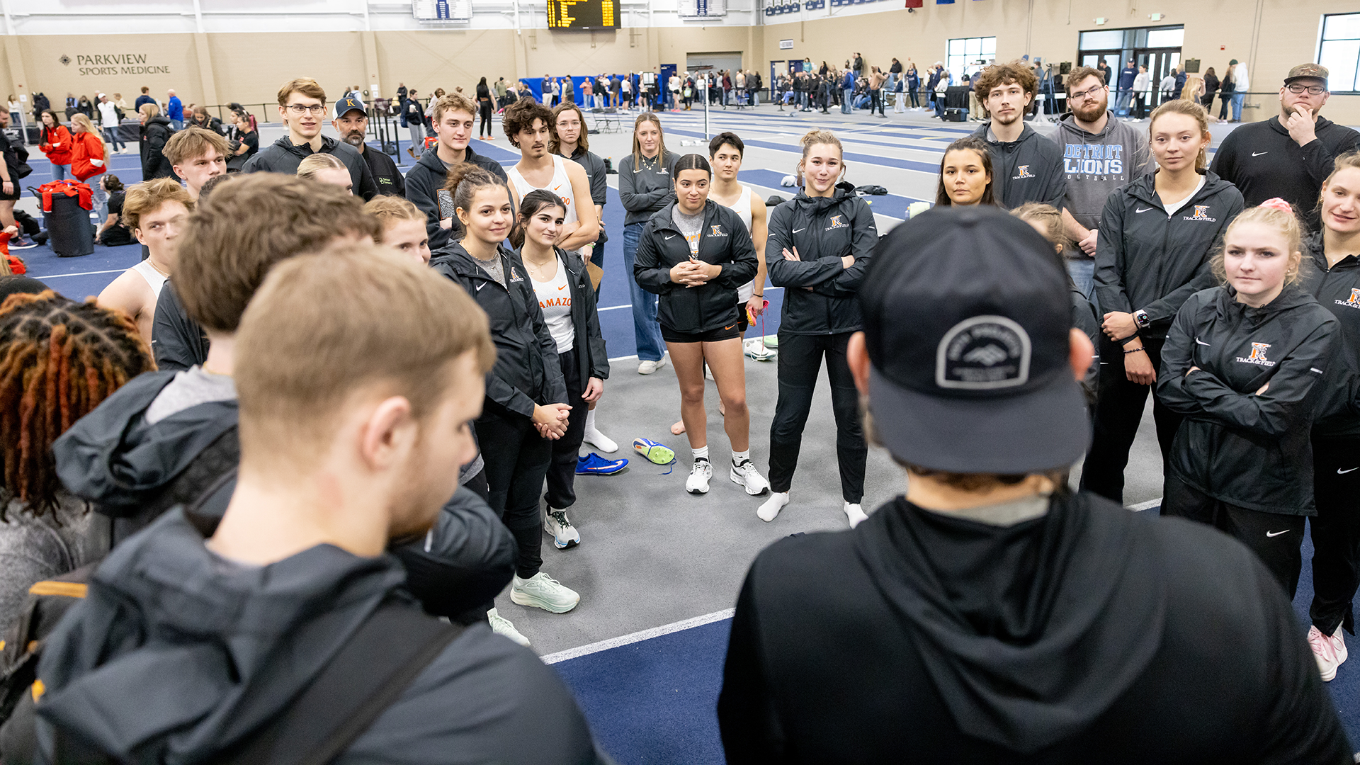 The Kalamazoo College track & field teams huddled around head coach Kyle Morrison