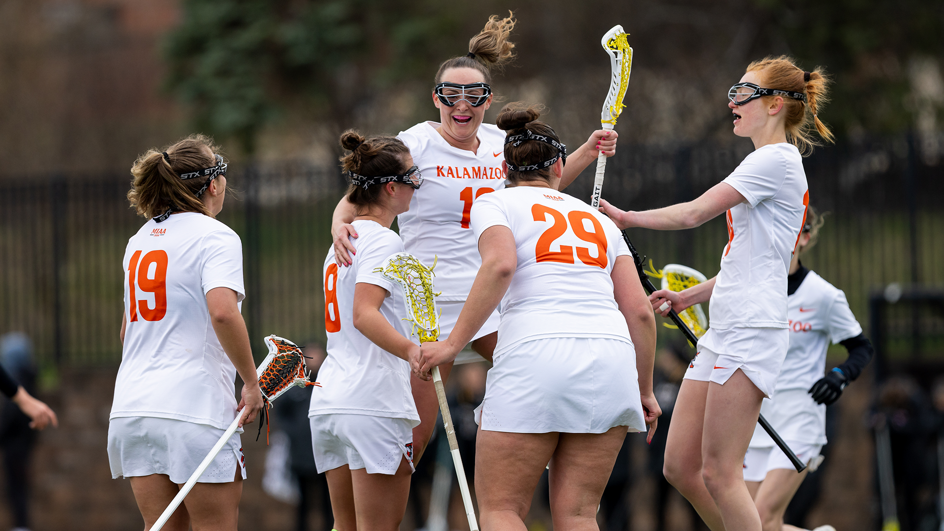 Ella Spooner celebrates a goal with her Kalamazoo  College women's lacrosse teammates
