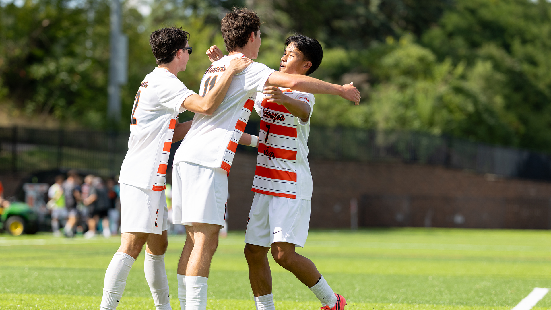 Elijah Vue celebrating a goal with Colby Connor and Eamonn Burns