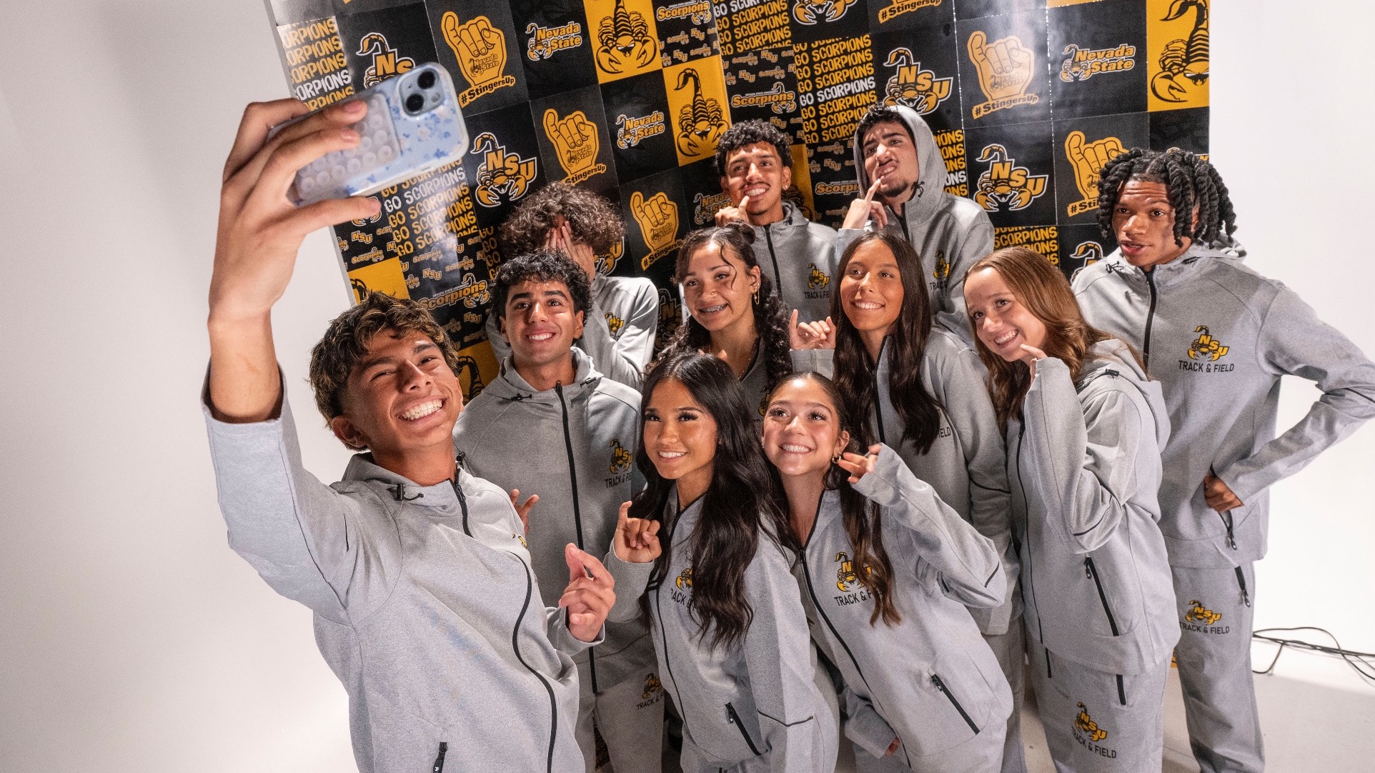 Members of the 2026 Women's and Men's Cross Country teams gather at their media day to take a group selfie.