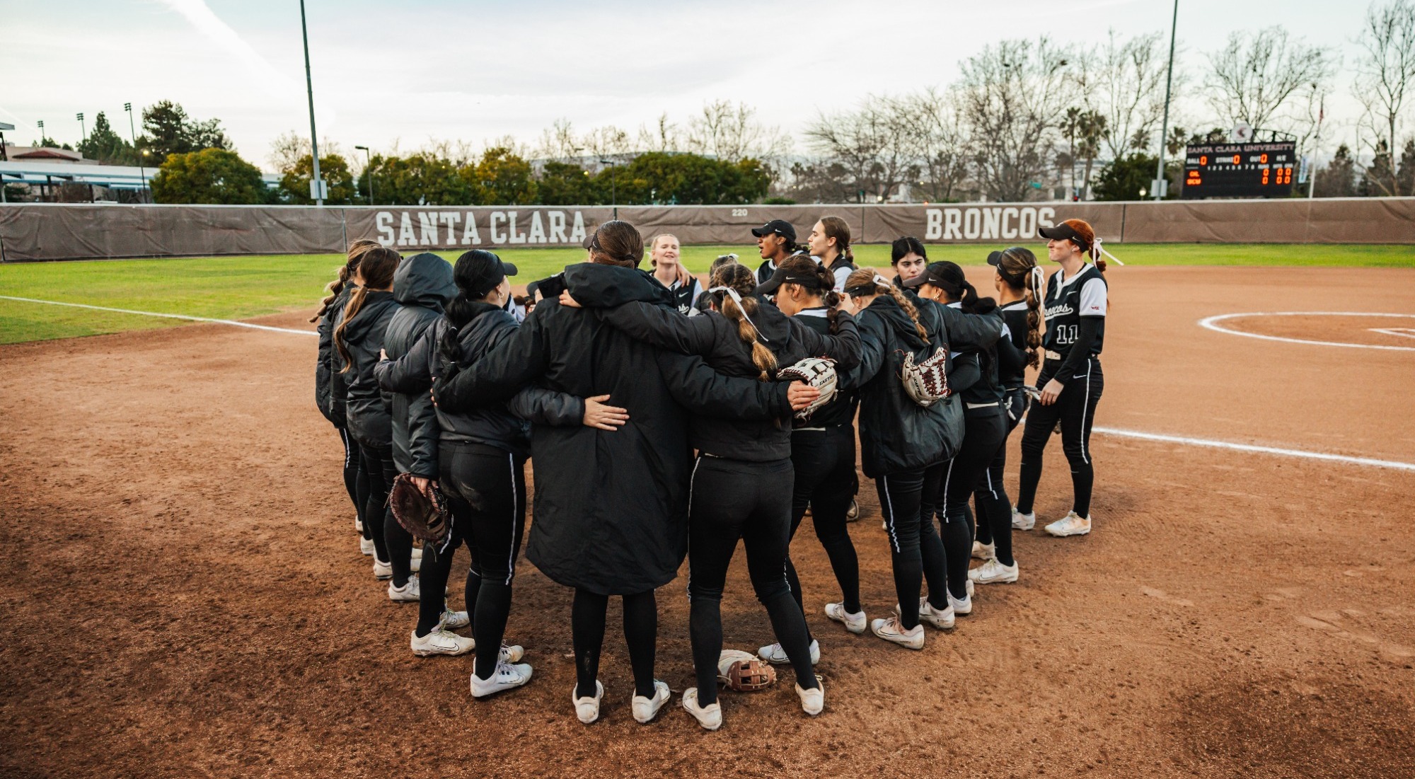 2026 Softball Team huddles near field vs. Cal.