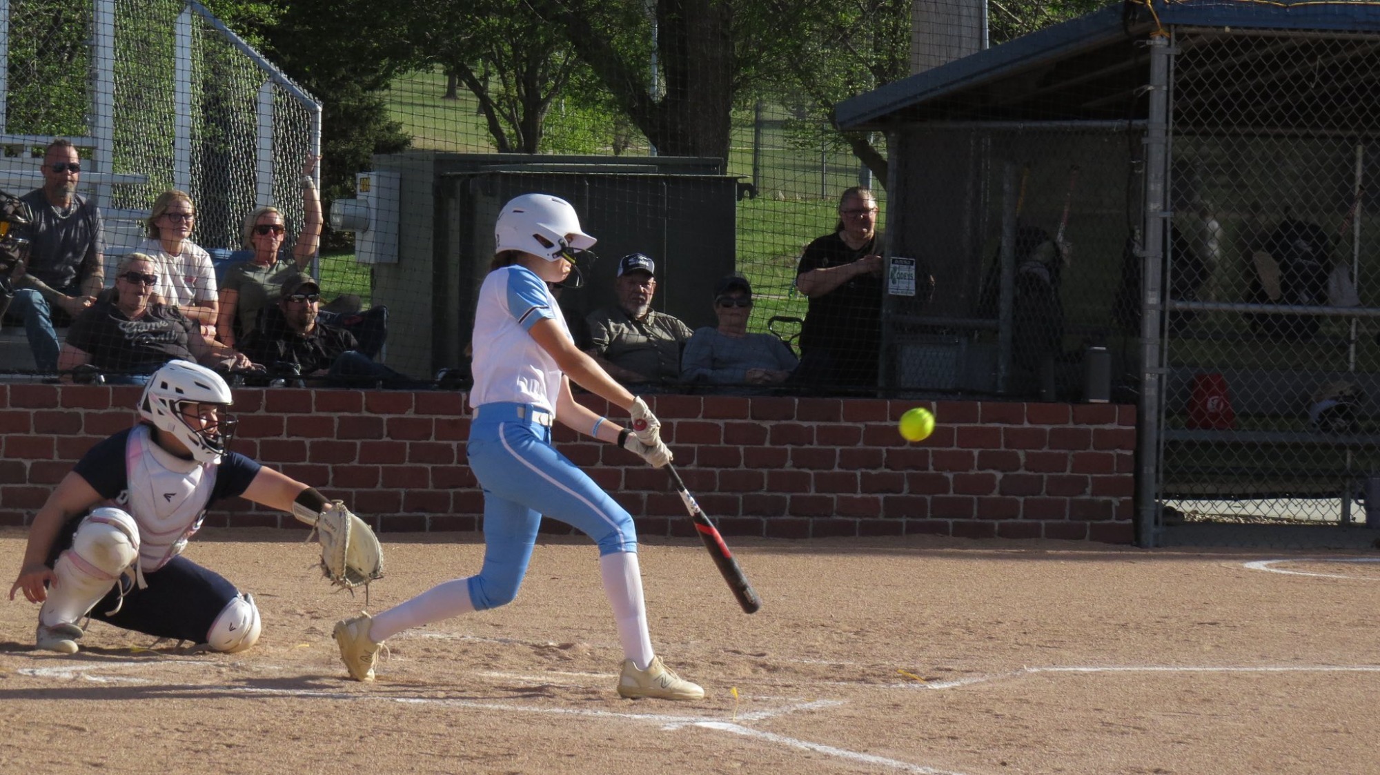 An SCC Softball player swings at a low pitch