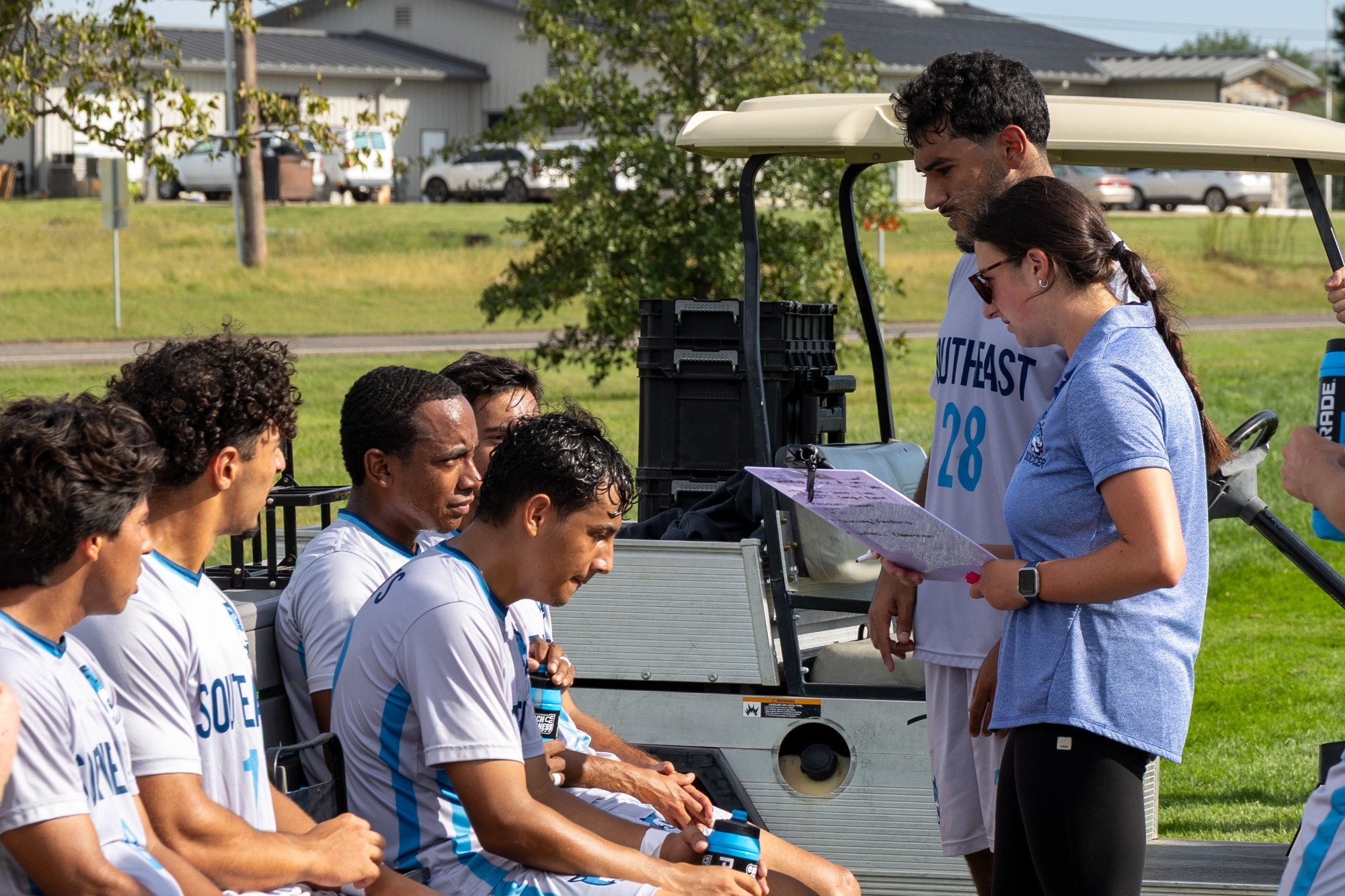 Head Coach Kiara Villaescusa talks with members of the men's soccer team during halftime.