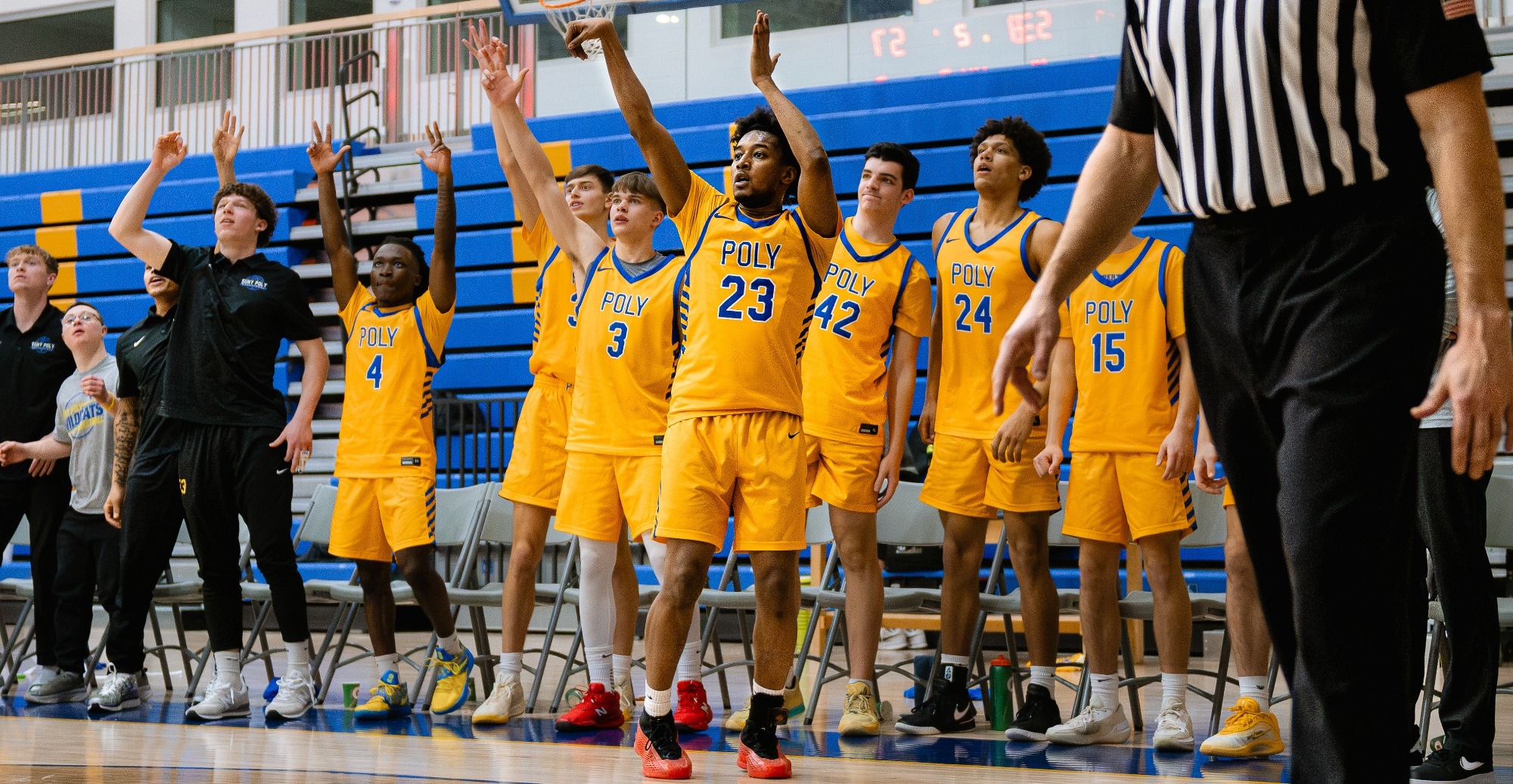 Men's Basketball team celebrates as player knocks down three point attempt