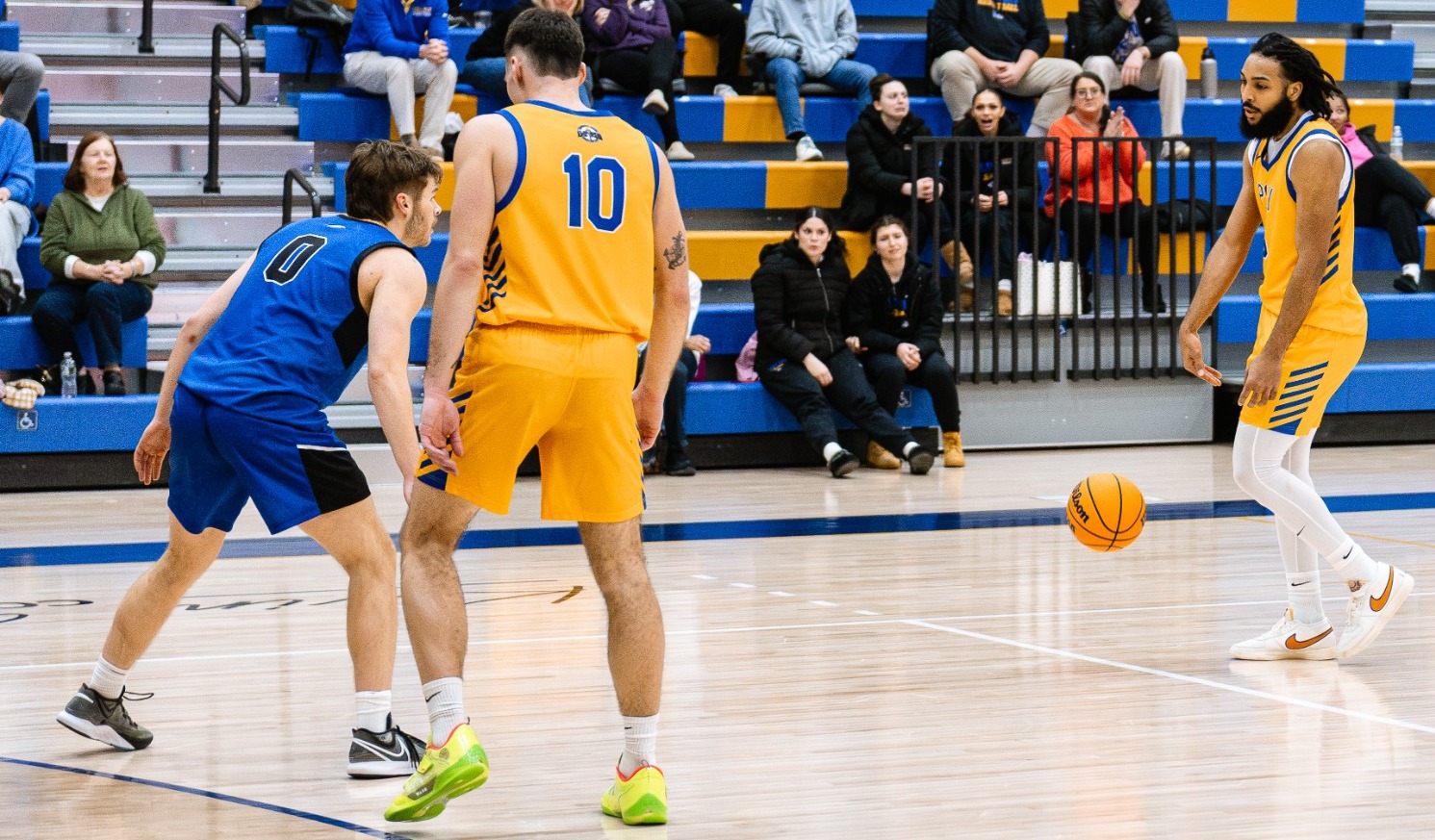 SUNY Poly men's basketball player dribbles up the court as his teammate gets ready to set a screen