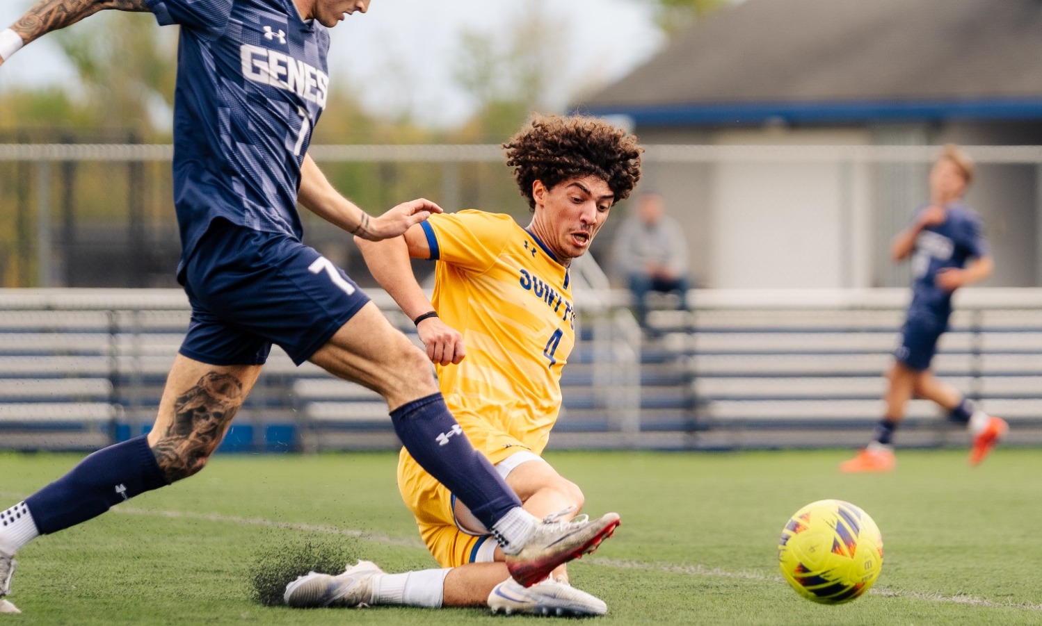 SUNY POLY men's soccer player makes sliding effort to stop incoming defender