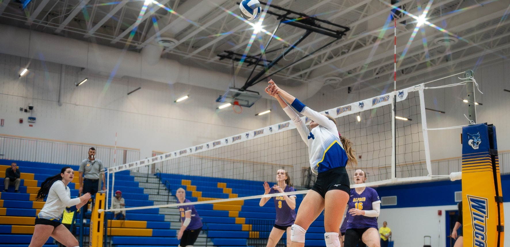 SUNY POLY Women's volleyball player sets the ball for attacking teammate