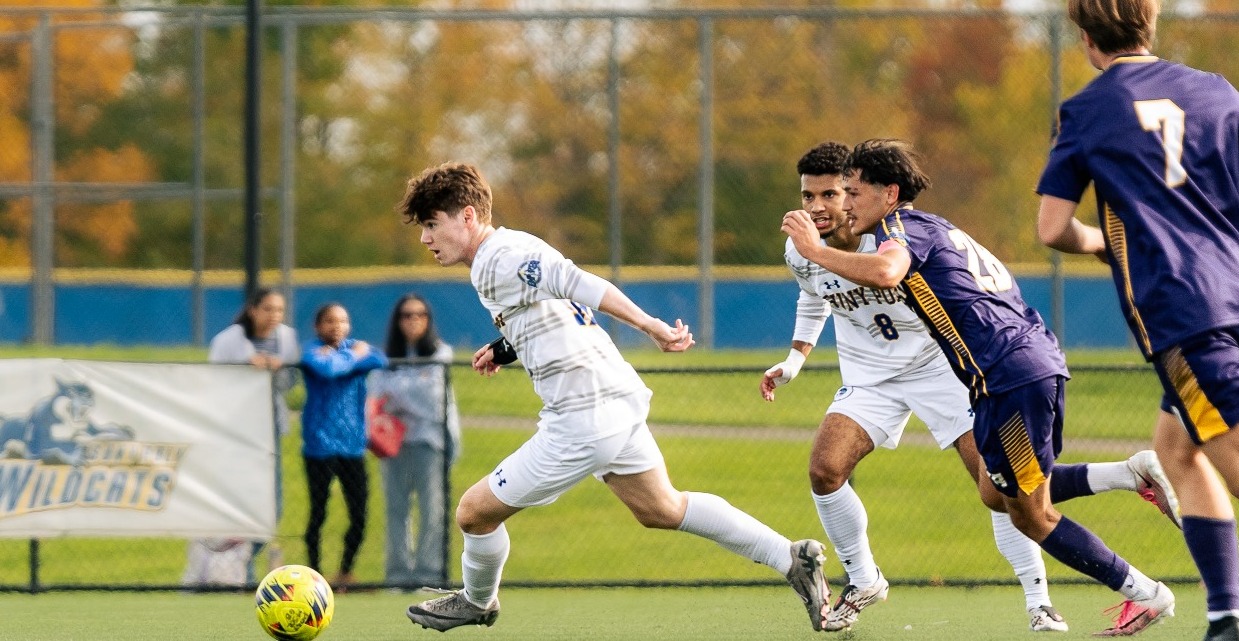 suny poly men's soccer player dribbles around defenders in attempt to work the ball upfield