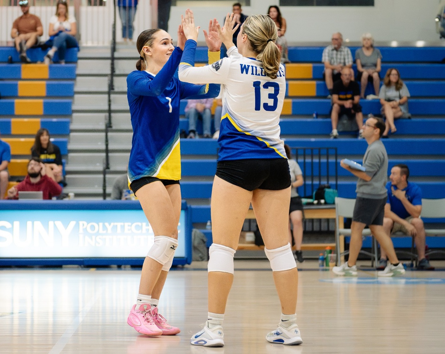 SUNY POLY women's volleyball team celebrates following a set win