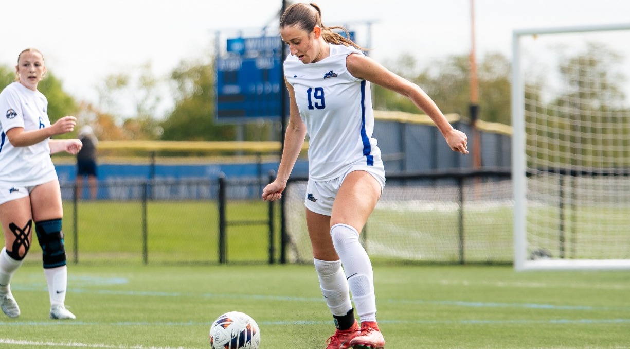 SUNY POLY women's soccer player dribbles the ball upfield 