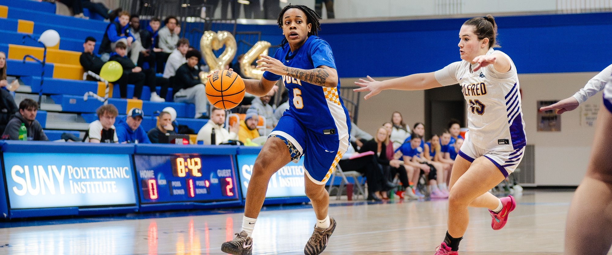 SUNY Poly women's basketball player drives to the basket 