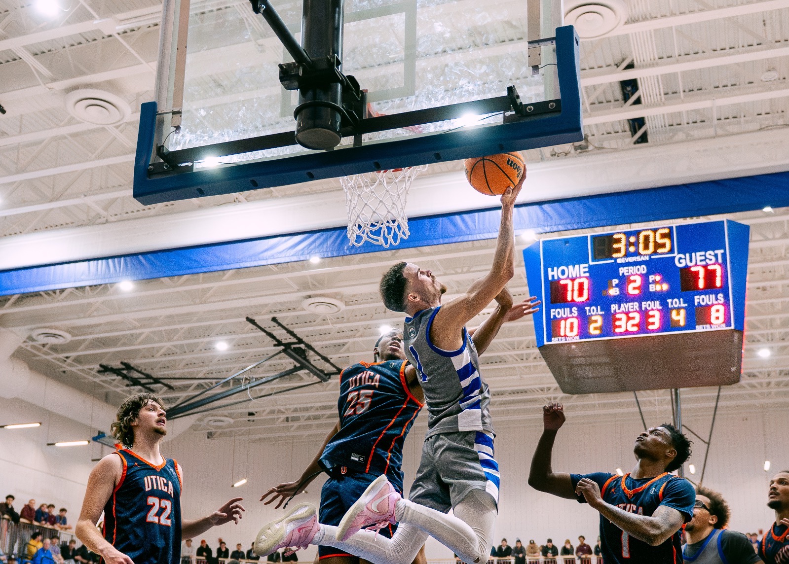 SUNY POLY men’s basketball players attempts a reverse layup 