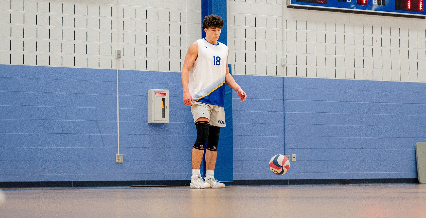 SUNY POLY men's volleyball player prepares to serve the ball