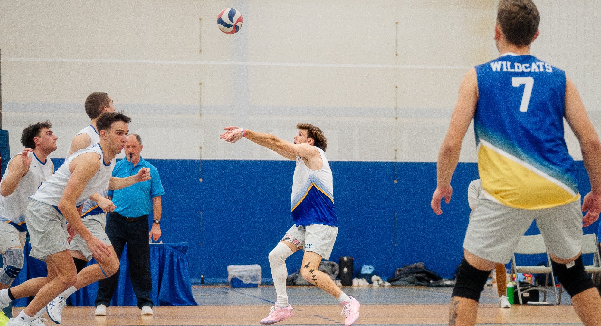 SUNY POLY men's volleyball player sets the ball for teammate