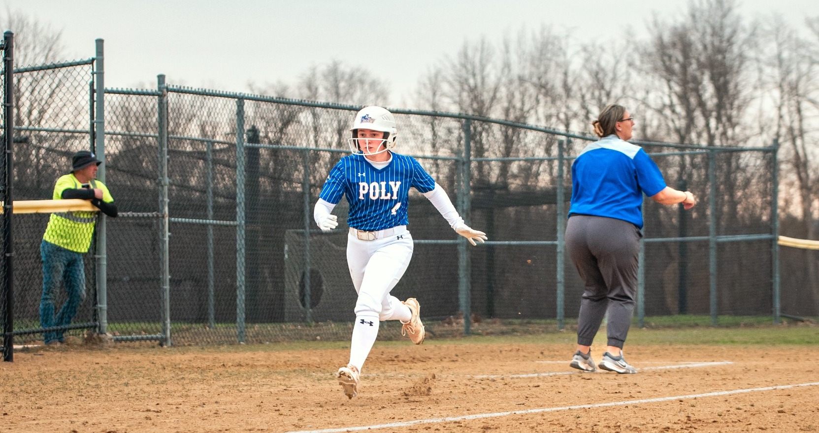 SUNY POLY softball player rounds third base and attempts to score 