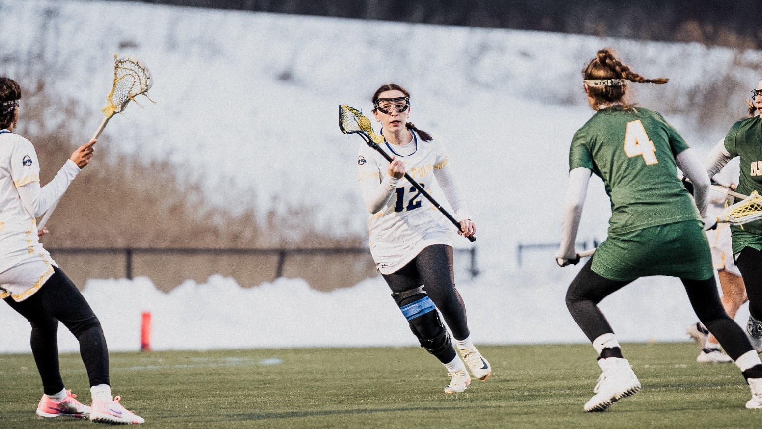 SUNY POLY lacrosse player looks for exit out of her own zone