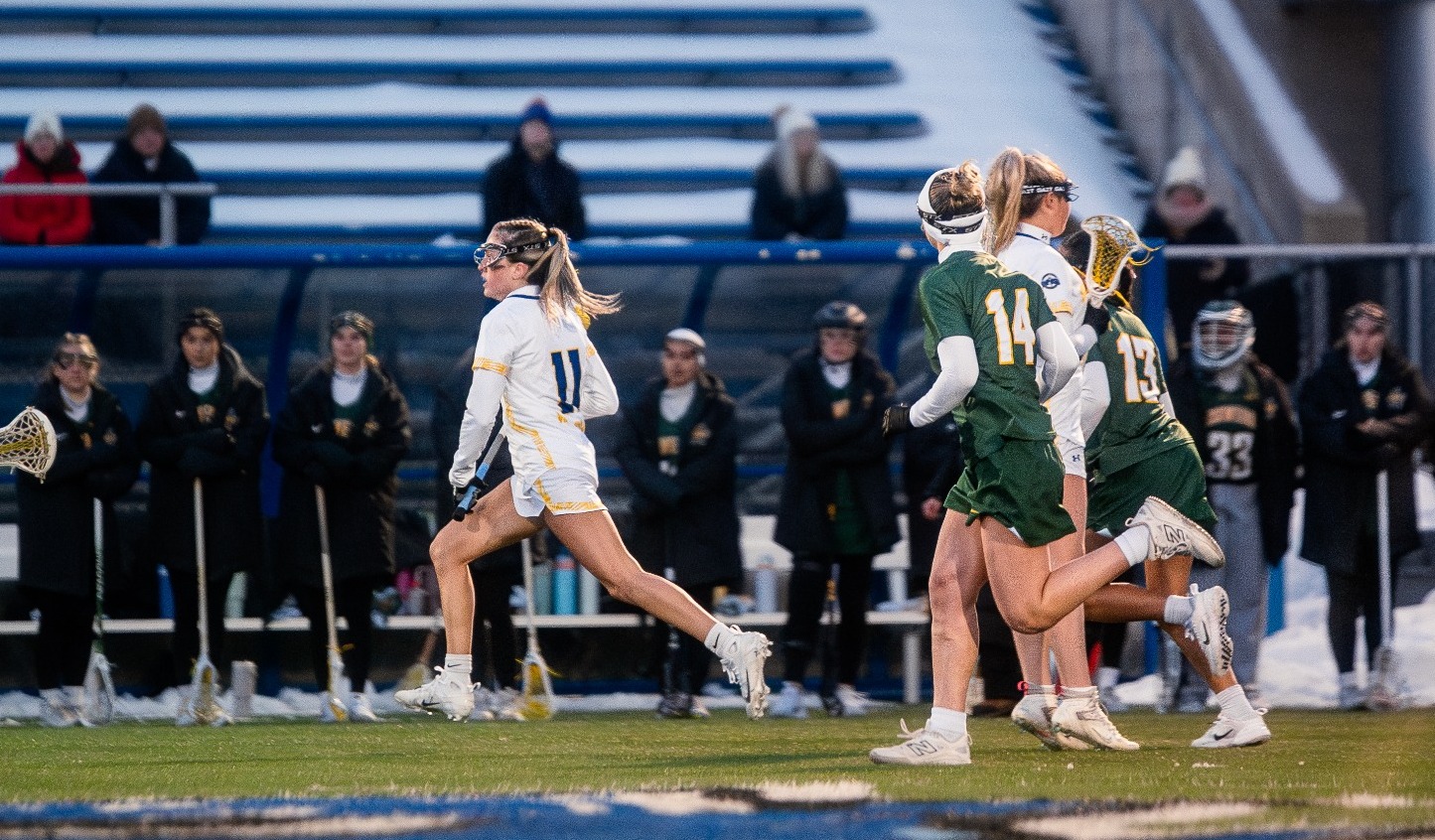 SUNY Poly lacrosse players makes effort to clear the ball from opponents