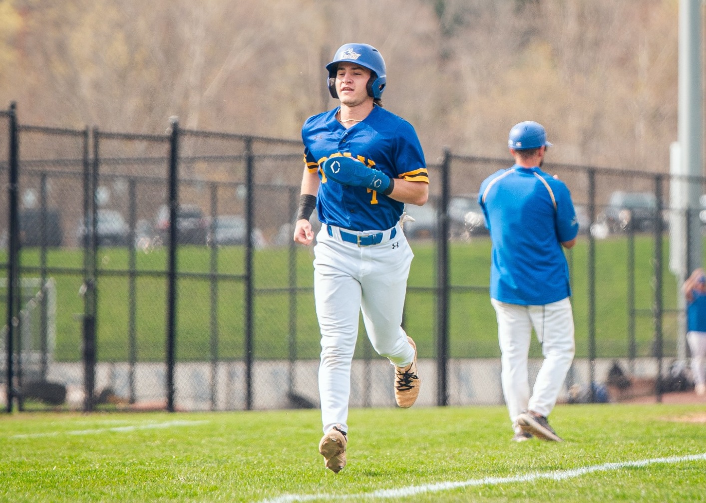SUNY Poly baseball players jogs home following a hit from his teammate
