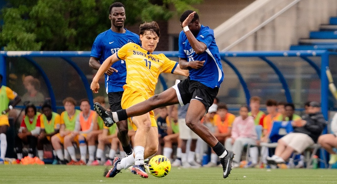 SUNY POLY mens soccer player makes sliding effort on the ball