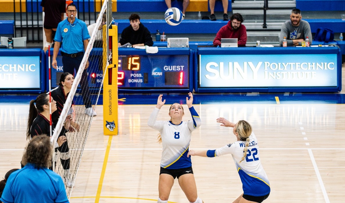 SUNY POLY women's volleyball players link up for an attack against the opposing team