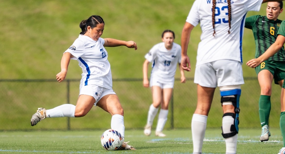 SUNY POLY women's soccer player gears up to take a shot from outside the box